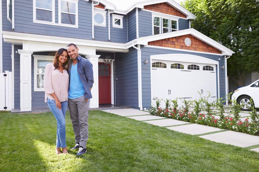 Couple standing in front of a blue house