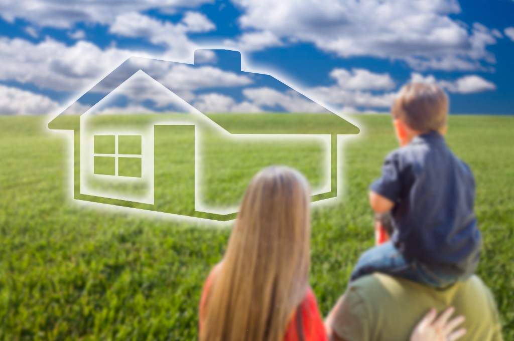 Silhouette of house in a field with bright blue sky